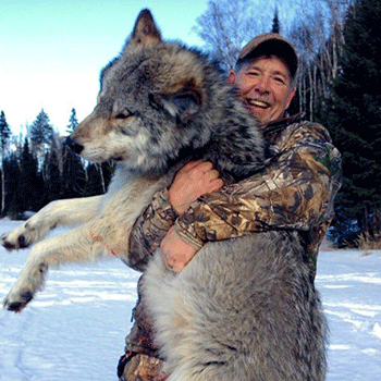 Hunters holds up his massive wolf catch